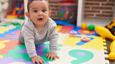 Toddler crawling on play mat