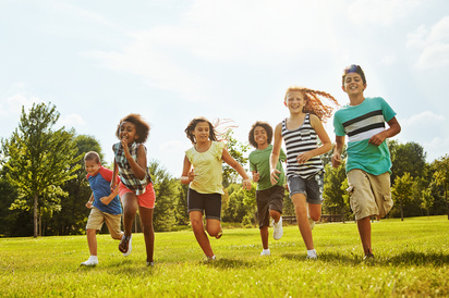Group of children running together through a field