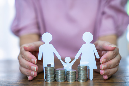 Paper stick people holding hands behind pile of coins