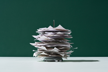 Stack of papers with metal spike going through the pile