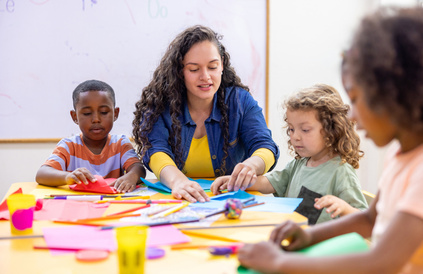 Worker sat with children doing arts and crafts