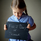 Child holding a first day at school sign 