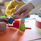 Child's and adults' hands playing with wooden toys
