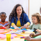 Worker sat with children doing arts and crafts
