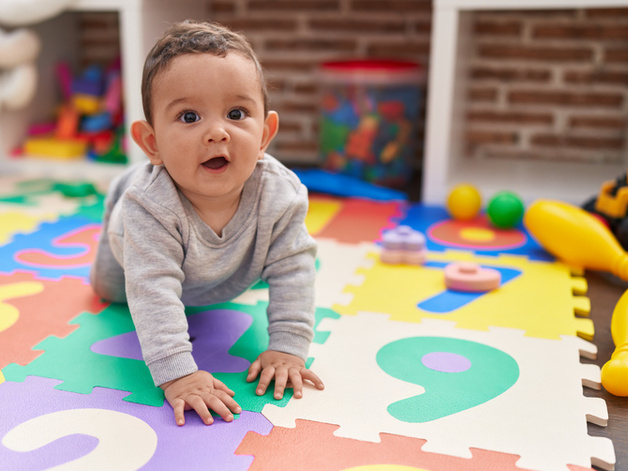 Toddler crawling on play mat