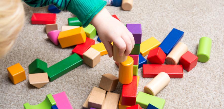 Baby boy playing with wooden construction toys