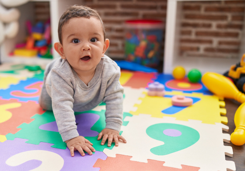 Toddler crawling on play mat
