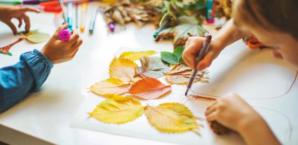 Child doing autumnal themed arts and crafts Children doing autumn hand crafts