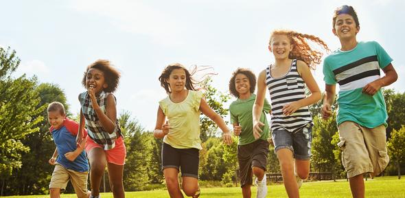 Group of children running together through a field Group of children running together through a field